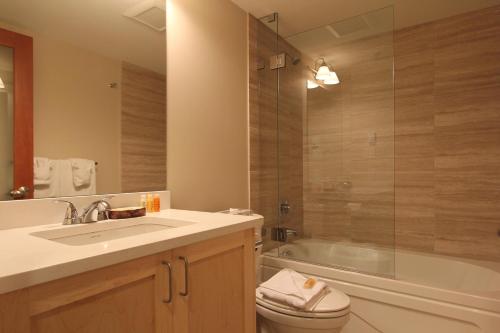 a bathroom with a sink and a toilet and a tub at Villas Snowberry by Whistler Retreats in Whistler