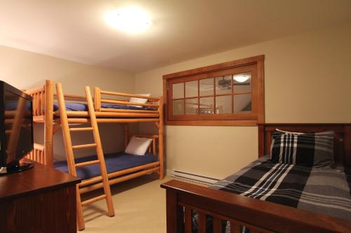 a bedroom with bunk beds and a desk and a bed at Villas Snowberry by Whistler Retreats in Whistler