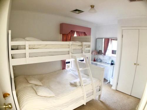 a bedroom with two bunk beds and a bathroom at Melbourne Garden Bed and Breakfast in Melton