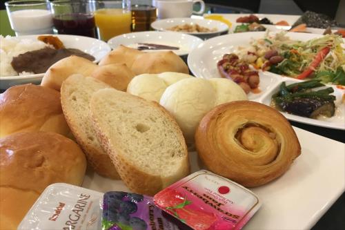 a plate of bread and pastries on a table at Green Rich Hotel Iwakuni Ekimae (Artificial hot spring Futamata Yunohana) in Iwakuni