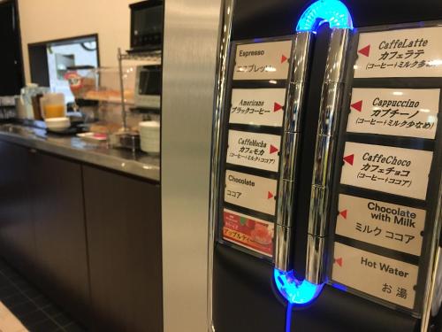 a refrigerator with a bunch of signs on it at Green Rich Hotel Iwakuni Ekimae (Artificial hot spring Futamata Yunohana) in Iwakuni