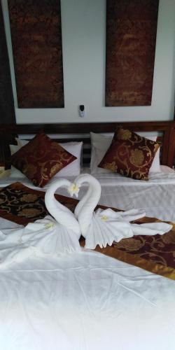 two swans made out of towels on a bed at Stunning villa with ocean views and free car in Lamai