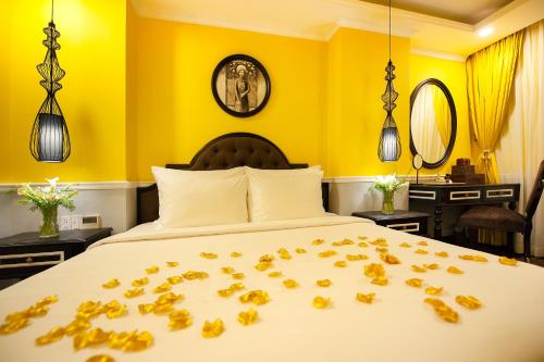 a bedroom with a bed with leaves on the bed at Adora Art Hotel in Ho Chi Minh City