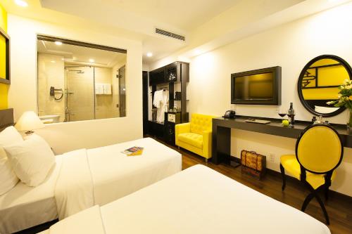 a hotel room with a bed and a mirror at Adora Art Hotel in Ho Chi Minh City