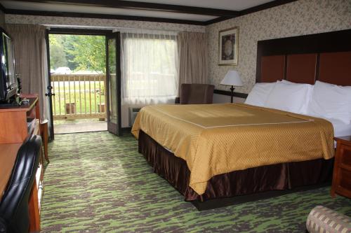 a hotel room with a bed and a balcony at Spring House Inn in Porter