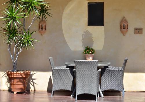 a table and chairs with plants on a patio at Villa San Michele (Official) in Port Douglas