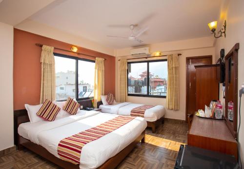 a hotel room with two beds and a large window at Hotel Crystal Palace in Pokhara