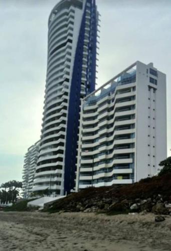 a large building on the beach next to a beach at Dpto Moderno Frente al Mar. Edf: Deymar 7mo Piso in Tonsupa