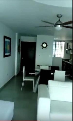 a living room with white furniture and a clock on the ceiling at Dpto Moderno Frente al Mar. Edf: Deymar 7mo Piso in Tonsupa