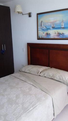 a bed in a bedroom with a picture on the wall at Dpto Moderno Frente al Mar. Edf: Deymar 7mo Piso in Tonsupa