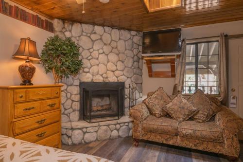 a living room with a stone fireplace and a couch at Black Forest Lodge in Big Bear Lake