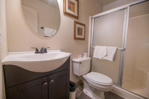 a bathroom with a sink and a toilet and a mirror at Black Forest Lodge in Big Bear Lake