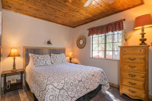 a bedroom with a bed and a dresser and a window at Black Forest Lodge in Big Bear Lake