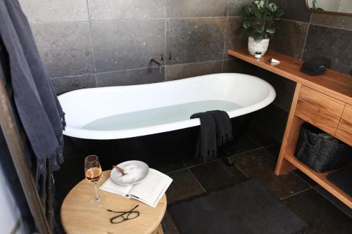 a bath tub with a table and a glass of wine at 28 Degrees Byron Bay - Adults Only in Byron Bay