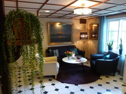 un soggiorno con un divano e un tavolo di Nya Pallas Hotel a Falkenberg