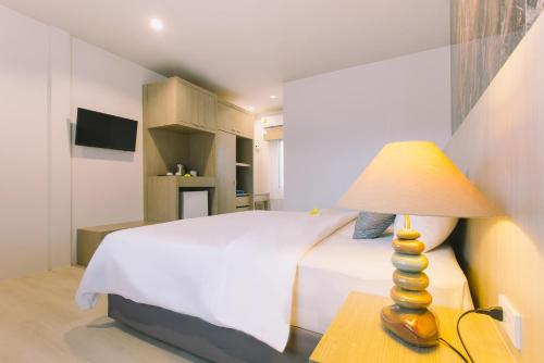 a bedroom with a bed and a lamp on a table at Fantasy Hill Bungalow in Kata Beach
