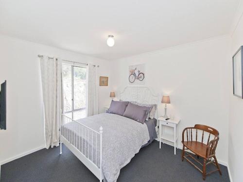 a bedroom with a bed and a chair and a window at Hahndorf Haven-Central Hahndorf in Hahndorf