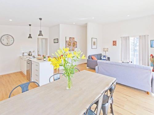 a kitchen and living room with a table and yellow flowers at Hahndorf Haven-Central Hahndorf in Hahndorf