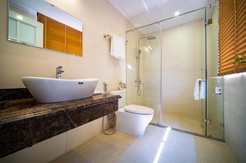 une salle de bain avec un lavabo et une douche dans l'établissement IDC White House Ha Long FLC Golf & Resort, à Hạ Long