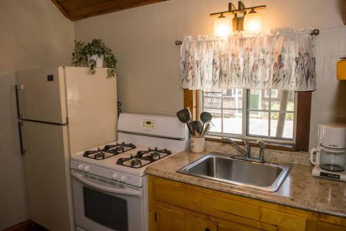 a kitchen with a stove and a sink and a refrigerator at Black Forest Lodge in Big Bear Lake