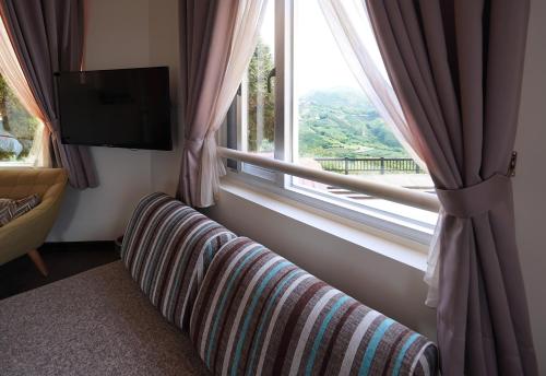 a living room with a couch and a window at SunSweet House in Fanlu