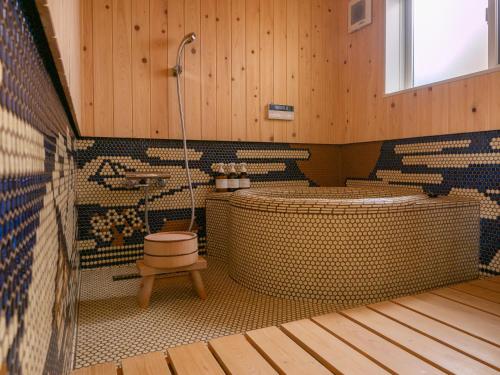 a bathroom with a tub and a shower and a toilet at Kyoto Machiya Cottage Karigane in Kyoto