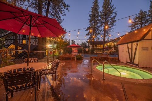 a hot tub with a table and chairs and an umbrella at Black Forest Lodge in Big Bear Lake