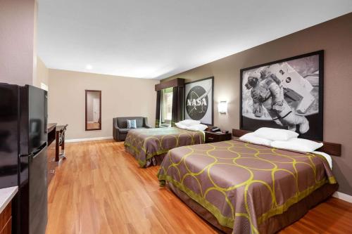 Habitación de hotel con 2 camas y TV de pantalla plana. en Super 8 by Wyndham Houston Northwest Cypress en Cypress