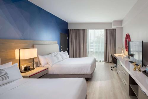 a hotel room with two beds and a television at The Summit Hotel in Cincinnati