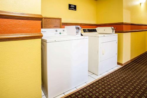 a washer and dryer in a room with yellow walls at Super 8 by Wyndham Crawfordsville in Crawfordsville