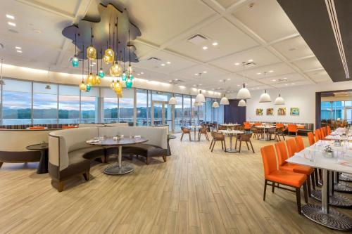 a restaurant with tables and chairs and windows at The Summit Hotel in Cincinnati