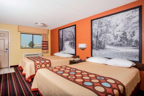 a hotel room with two beds and a picture on the wall at Super 8 by Wyndham Crawfordsville in Crawfordsville
