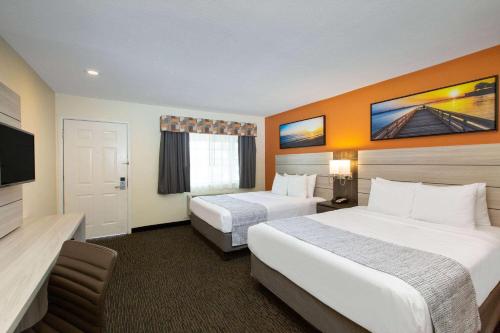 a hotel room with two beds and a television at Days Inn by Wyndham Monterey-Fisherman's Wharf Aquarium in Monterey