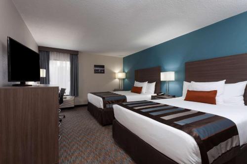 a hotel room with two beds and a flat screen tv at Nobile Hotel Parkway at Celebration Orlando Very Close to Disney Theme Parks in Orlando