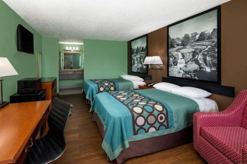 a hotel room with two beds and a desk and a chair at Super 8 by Wyndham Gaffney in Gaffney