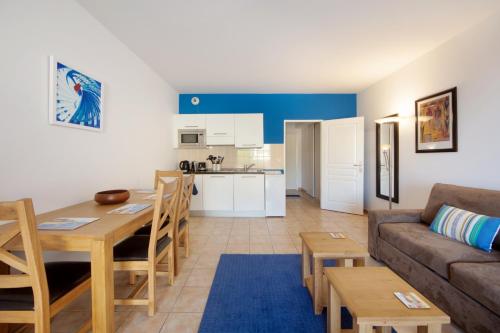 un salon et une cuisine avec un canapé et une table dans l'établissement Monaco, sea view, bright studio, à Beausoleil