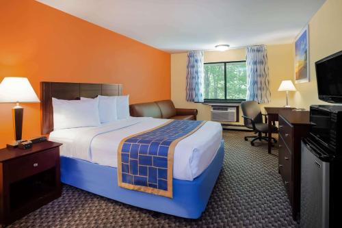 Habitación de hotel con cama grande y escritorio. en Days Inn & Suites by Wyndham Stevens Point en Stevens Point