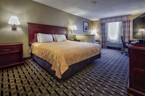 A bed or beds in a room at Quality Inn Moore - Oklahoma City