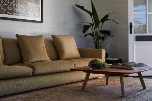 a brown couch in a living room with a coffee table at 28 Degrees Byron Bay - Adults Only in Byron Bay