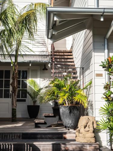 a house with palm trees on the front porch at 28 Degrees Byron Bay - Adults Only in Byron Bay