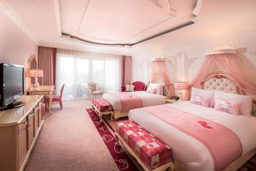 a hotel room with two beds and a television at Lotte Hotel Jeju in Seogwipo