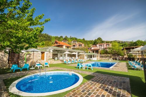 a swimming pool in a yard with chairs and a house at Ilaeira Mountain Resort in Tóriza