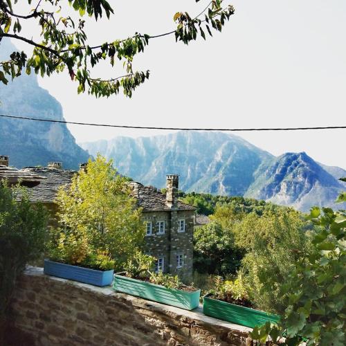 an old house with mountains in the background at Morfeas Guesthouse in Papigko