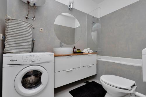 a bathroom with a washing machine and a toilet at Apartments Ratac in Tučepi