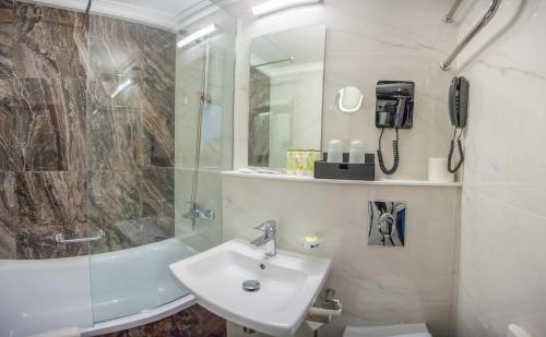 ハバロフスクにあるホテル インツーリストの白いバスルーム(シンク、シャワー付)