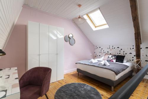 a bedroom with a bed and a chair at La Sonate by Cocoonr in Rennes