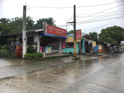 a street with a store on a rain soaked street at Budget Rooms in Silang Near Tagaytay in Silang