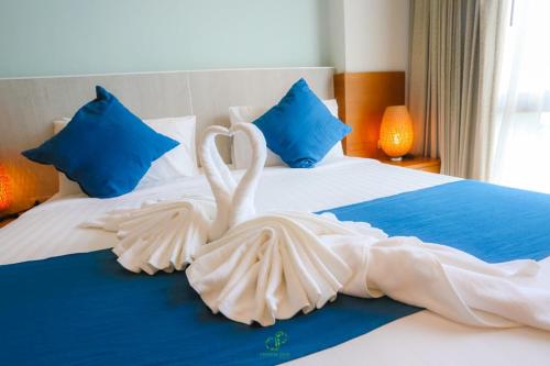 two white swans are sitting on a bed at Crystal Jade Hotel in Rayong