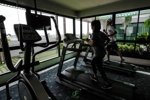 a woman running on a treadmill in a gym at Crystal Jade Hotel in Rayong