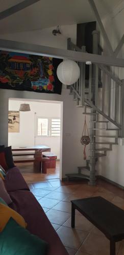 a living room with a staircase and a couch at La Maison Dakoté in Sainte-Clotilde